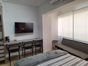 a bedroom with a bed and a table with chairs at Studio Butantã Novíssimo in São Paulo