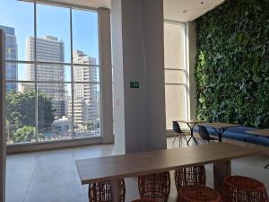 a room with a table and chairs and a large window at Studio Butantã Novíssimo in São Paulo +12 photos