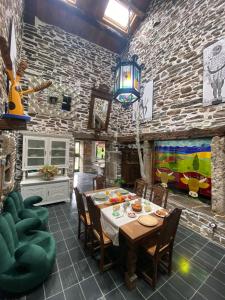 a dining room with a table and a stone wall at O Forno de Catuxa Cottage & Roman Wall in Lugo