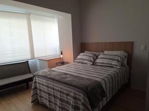 a bedroom with a large bed and a window at Studio Butantã Novíssimo in São Paulo