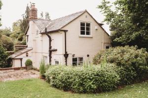 an old house with a garden in front of it at Cotswolds Manor Gatehouse with Log Burner in Bredon