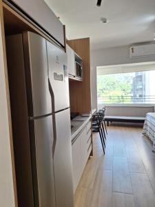 a kitchen with a refrigerator and a dining room at Studio Butantã Novíssimo in São Paulo