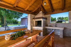 een grote buitenkeuken met een stenen open haard bij Villa Emanuel in Barban