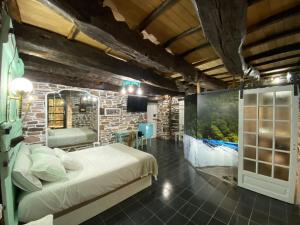 a bedroom with a bed and a brick wall at O Forno de Catuxa Cottage & Roman Wall in Lugo