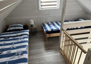 a room with two beds and a staircase in a house at Domkoland in Dziwnówek