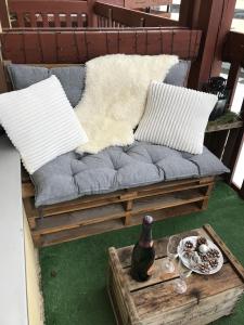 een bank met kussens en een tafel met een wijnfles bij Le Solaret in Bourg-Saint-Maurice