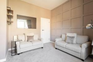 a living room with two chairs and a mirror at Host & Stay - High Street in Loftus
