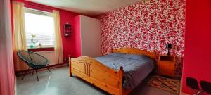 a bedroom with a wooden bed and a red wall at Småland Eksjö 2 mooie appartementen in Höreda