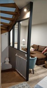 Una sala de estar con un sofá y un espejo. en Maison de la cité des 3 vallées, en Saint-Brieuc