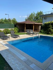 サパンジャにあるGölyolu Villa Ayのラウンジチェア2脚付きのスイミングプール、家