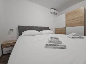 a bedroom with a white bed with towels on it at Vila Lavanda Povljana in Povljana
