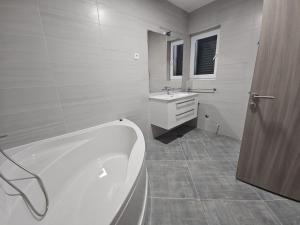 a white bathroom with a tub and a sink at Vila Lavanda Povljana in Povljana