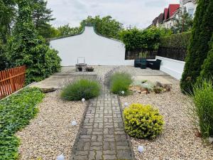 Un jardín con un camino de piedra y plantas. en Zöldfa Apartmanház - Tetőtér, en Eger