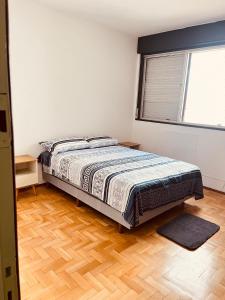 ein Schlafzimmer mit einem Bett und einem Holzboden in der Unterkunft 301- Apartamento 2 quartos próximo UFN, com garagem in Santa Maria