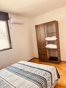 ein Schlafzimmer mit einem Bett und einem Regal mit Handtüchern in der Unterkunft 301- Apartamento 2 quartos próximo UFN, com garagem in Santa Maria