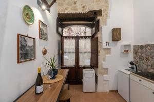 a kitchen with a table and a sink and a toilet at Casa Ariadne by Ortigia Apartments in Syracuse