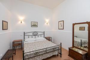 a bedroom with a bed and a mirror at Casa Ariadne by Ortigia Apartments in Syracuse