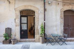 a table and chairs in front of a building at Casa Ariadne by Ortigia Apartments in Syracuse