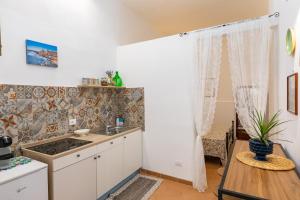 a kitchen with a sink and a table at Casa Ariadne by Ortigia Apartments in Syracuse +19 photos