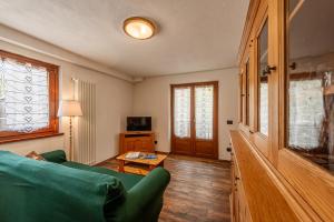een woonkamer met een groene bank en een tafel bij CHALET PONTAL 11 - Relax e vista sulle montagne - COUR 0154 in Courmayeur