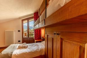 een slaapkamer met een bed en een groot raam bij CHALET PONTAL 11 - Relax e vista sulle montagne - COUR 0154 in Courmayeur