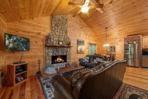 a living room with a couch and a fireplace at The cozy Lazy Laurel with year-round mountain views, hot tub, fire pit in Cherry Log