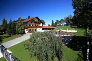 una casa en una colina con un árbol delante en Landhaus Frauenberg, en Haidmühle