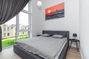 a bedroom with a bed and a large window at J7 Beržas 7A-1 in Palanga +12 photos