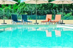 a group of chairs and umbrellas next to a swimming pool at Hôtel Du Viaduc in Tarascon