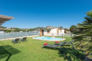 a backyard with a pool and chairs and a palm tree at Hermosa Finca Padre in Son Servera