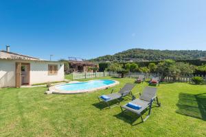 a yard with two chairs and a swimming pool at Hermosa Finca Padre in Son Servera