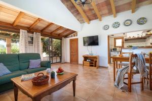 a living room with a green couch and a table at Hermosa Finca Padre in Son Servera