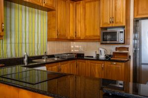 Una cocina con gabinetes de madera y electrodomésticos de acero inoxidable. en Seanique Holiday Home, en Margate