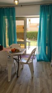 a table and chairs in a room with blue curtains at New venisia Resort in Ain Sokhna
