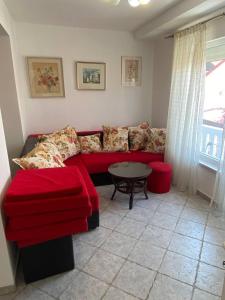 a living room with a red couch and a table at Дом возле моря с большой террасой с видом на море in Utjeha