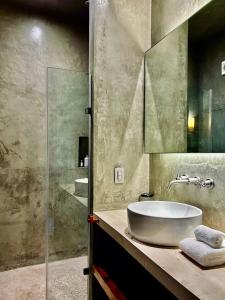 een badkamer met een wastafel en een glazen douche bij Original studios by Casago in Tulum