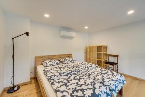 a bedroom with a bed with a blue and white comforter at Uptown Lofts in Vilnius +16 photos