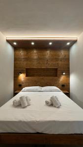 un grande letto bianco con due asciugamani sopra di Hostdomus- Bear Suite a Sestriere