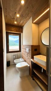 bagno con 2 lavandini, servizi igienici e vasca di Hostdomus- Bear Suite a Sestriere