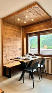una sala da pranzo con tavolo e sedie di Hostdomus- Bear Suite a Sestriere Altre 6 foto