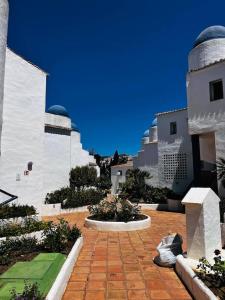a brick courtyard with a building and a blue sky at Apartamento Lagarto in Sitio de Calahonda