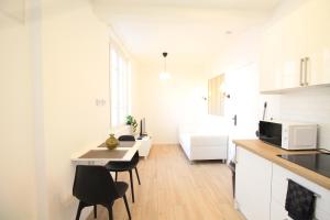 a kitchen with a table and chairs in a room at Disponible - Appartement Entier - Matelas Emma - RER B Laplace, 5mn Paris - 2 pers - Parking Rue Gratuit - Tout équipé - RDC - 1 in Arcueil