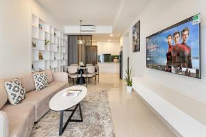 a living room with a couch and a large screen at Otis Soho Saigon Balcony Apartment in Ho Chi Minh City