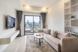 a living room with a couch and a table at Otis Soho Saigon Balcony Apartment in Ho Chi Minh City