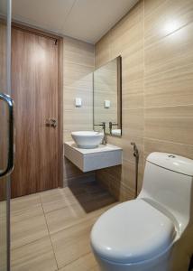 a bathroom with a white toilet and a sink at Otis Soho Saigon Balcony Apartment in Ho Chi Minh City