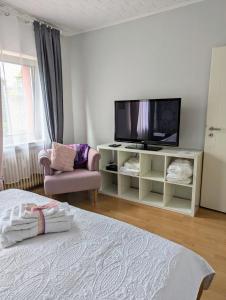 a living room with a tv and a bed at Charmantes kleines Gästehaus PIA, zentral in Bedburg in Bedburg