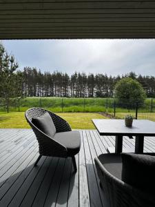 a patio with a table and a chair and a table at Atostogų namai MUDU - Takas į jūrą 2 kvartale in Palanga