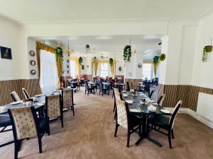 a dining room filled with tables and chairs at Four Oaks Hotel in Llandudno