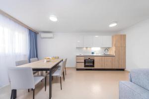 eine Küche und ein Esszimmer mit Tisch und Stühlen in der Unterkunft Garden Sunset Suite Apartment in Umag