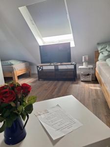 ein Wohnzimmer mit einer Vase aus Rosen auf dem Tisch in der Unterkunft Logger in Emden